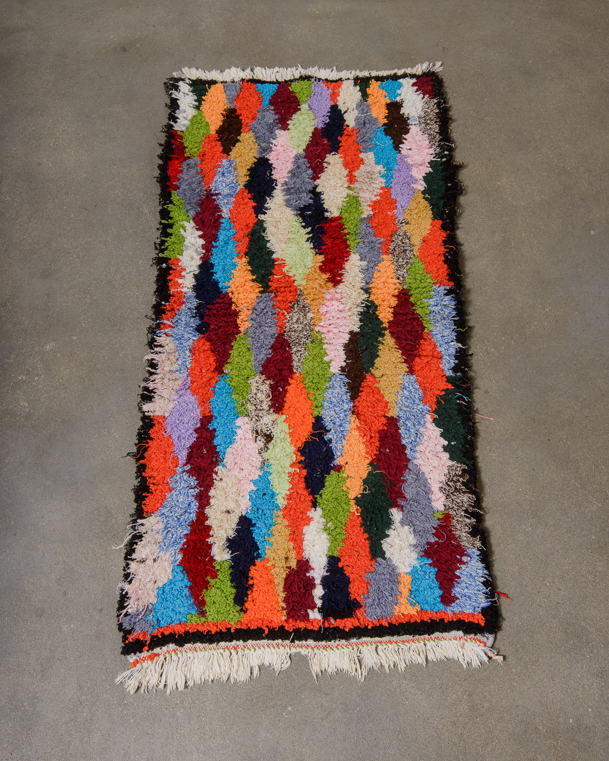 Multicoloured geometric patterned rug on a grey concrete floor